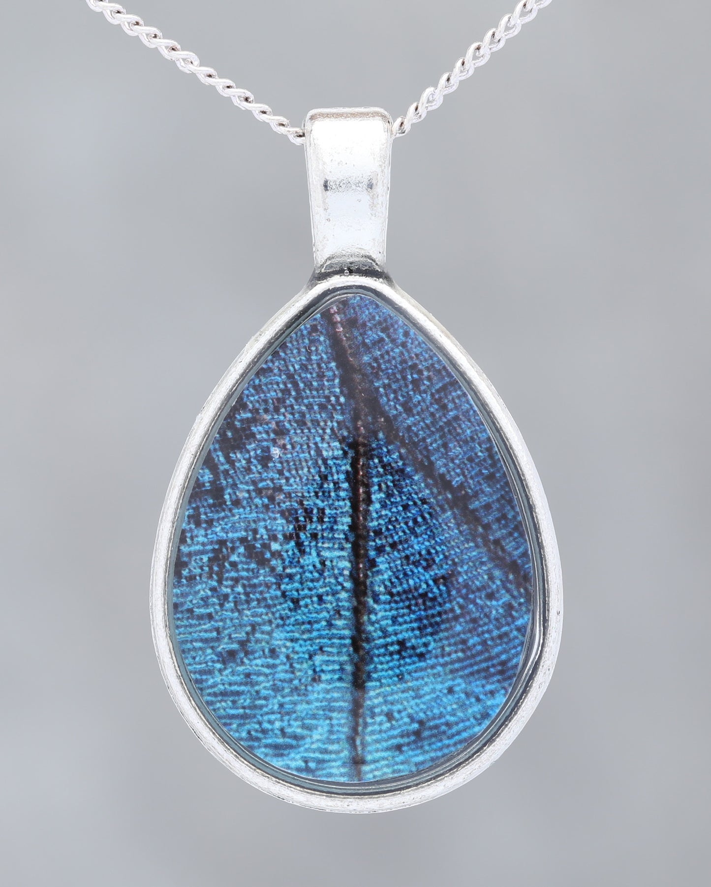 Blue Morpho  - Glow-in-the-dark pendant with an image of a Butterfly's wing set in a blue stone-like bezel