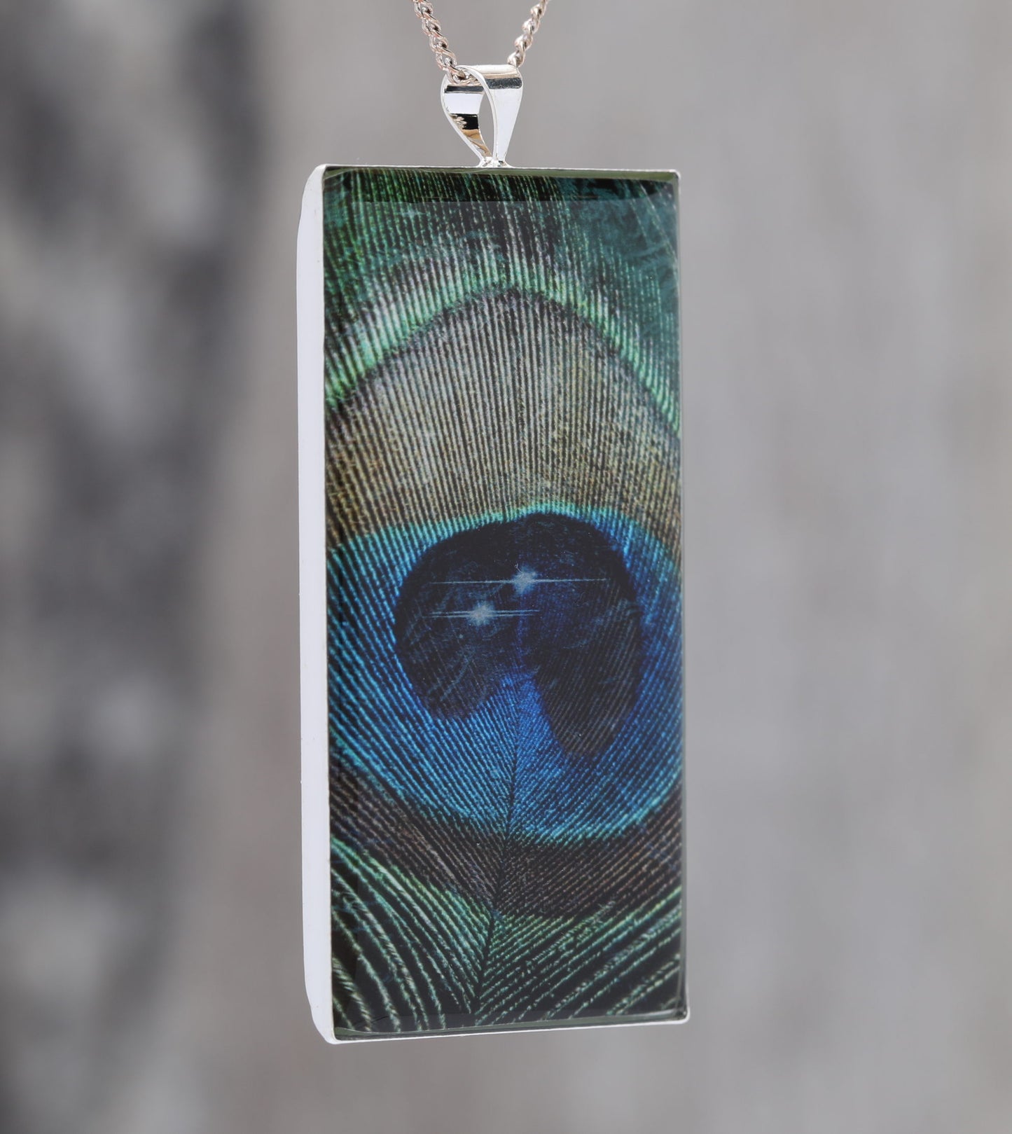 Feathers in Space  - Glow-in-the-dark pendant with a beautiful Peacock feather and star pattern