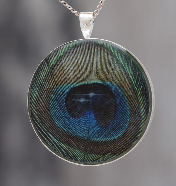 Feathers in Space  - Glow-in-the-dark pendant with a beautiful Peacock feather and star pattern